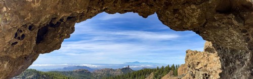 View through a rock arch to Roque Nublo and the Teide mountain peak on the neighbouring island of Tenerife