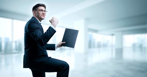 Man with a tablet in his hand screams with joy in the office. The concept of achieving success in business.