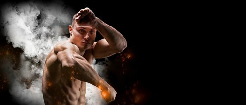 Professional boxer posing in the studio. He stands in front of the camera and elbows. The concept of sport