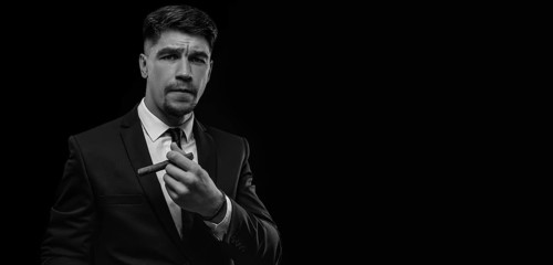 Portrait of a stylish man in a suit with a cigar. Business concept.