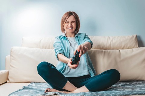 Girl with a joystick in her hands enthusiastically plays a computer game. ESports concept.