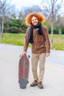 Vertical portrait of an skater in an urban park in autumn