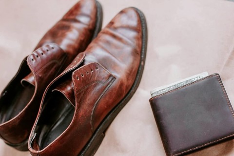 Brown men's shoes made of genuine leather and a brown leather wallet with money