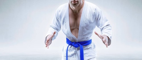 Sportsman in a kimono with a blue belt. The concept of karate and judo competitions.