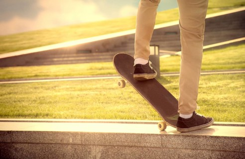 Desperate skateboarder performs dangerous movement on the skateboard at sunset