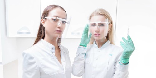 Portrait of two girls in white coats. The concept of cosmetology