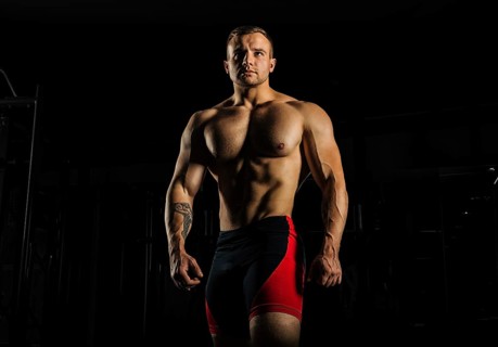 Portrait of a weightlifter who poses without a shirt. Front view