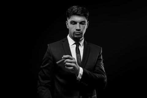 Portrait of a stylish man in a suit with a cigar. Business concept.