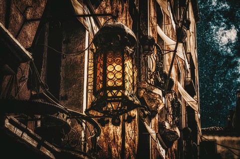 Mystical old lantern on the wall of a house. The concept of the struggle between good and evil. Education.