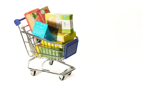 Shopping cart full of boxes of grocery items isolated on a white background