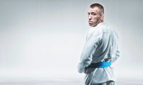 Strong man in a kimono looks over his shoulder. Concept of karate