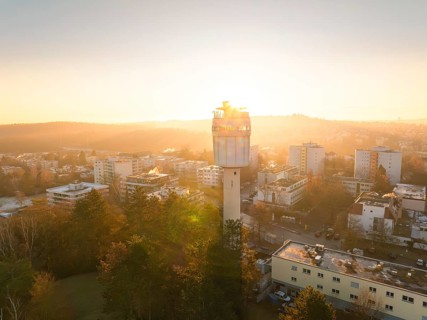 Aerial view morning mood with the sunlight illuminating a water tower and the city