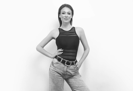 Portrait of a girl in a bodysuit and jeans. Women's underwear concept.