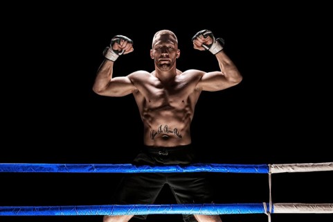 Kickboxer posing in the ring. The athlete climbed the ropes and took a winning pose. The concept of mma
