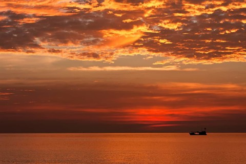 Red sunset and fishing boat