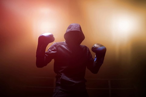 Fighter without a face is standing with his hands up. The concept of boxing