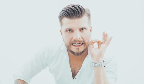 Stylish man in a shirt shows an ok sign right at the camera. The concept of success and support
