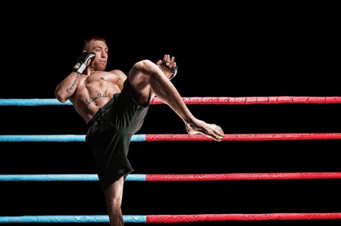 Thai boxer in the ring hits with a knee. The concept of sports