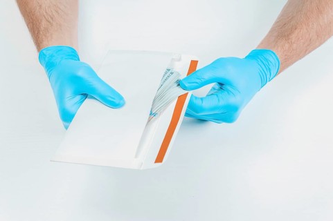 Image of hands in medical gloves holding an envelope with dollars. The concept of corruption in medicine.
