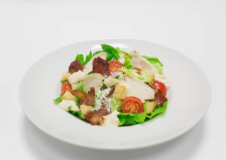 Gourmet Caesar Salad with Bacon. Top view. White background. Healthy eating concept.