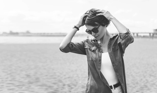 Image of a beautiful woman on the beach of the Gulf of Finland in St. Petersburg. Windy weather. Happiness