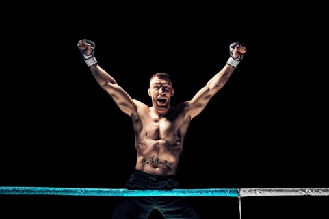 Kickboxer posing in the ring. The athlete climbed the ropes and took a winning pose. The concept of mma