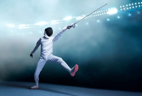 The fencer moves forward with a sword in his hand. Sport concept.