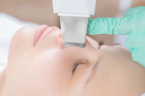 Young pretty woman receiving treatments in beauty salons. Ultrasonic cleaning procedure. Hardware cosmetology.