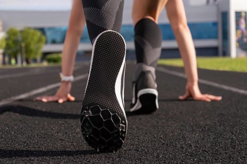 Professional runner stands on the track and prepares for the start of the race. Sports concept.