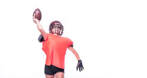 Woman in the uniform of an American football team player throws the ball. Sports concept.