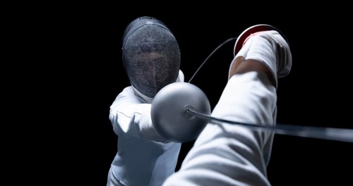 Two fencers are fighting in a tournament. The concept of fencing.