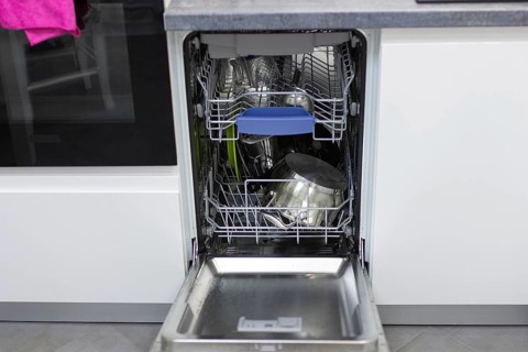 White modern dishwasher in the interior of a white kitchen