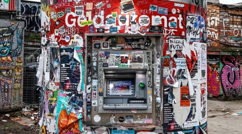 ATM with graffiti and stickers on the RAW site. The RAW site is the former Reichsbahn repair works in the Friedrichshain district. Today