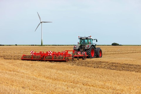 Tractor pulls a harrow behind it