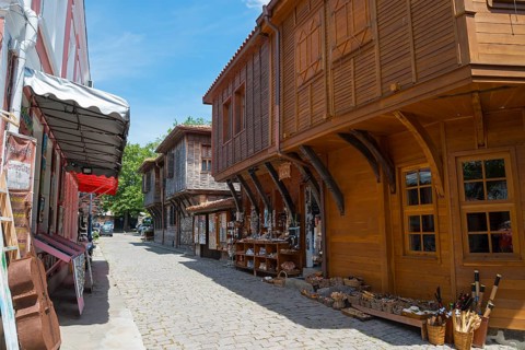 Cobbled street surrounded by shops with traditional wooden facades under a clear blue sky