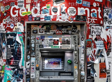 ATM with graffiti and stickers on the RAW site. The RAW site is the former Reichsbahn repair works in the Friedrichshain district. Today