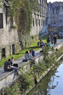 People resting on quay along the Groot Vleeshuis