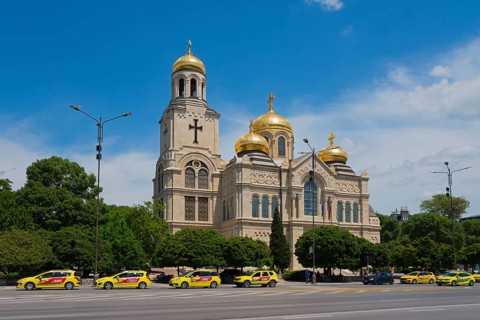Golden domes of a church stand out under a clear blue sky