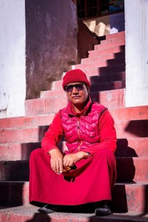 A monk sitting on the stairs to Korzok monastery