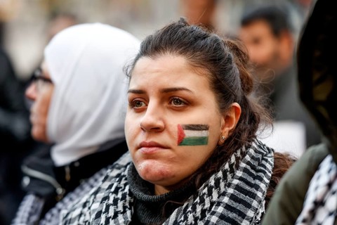 A participant in the Freedom for the People of Gaza demonstration has painted the Palestinian flag on her cheek