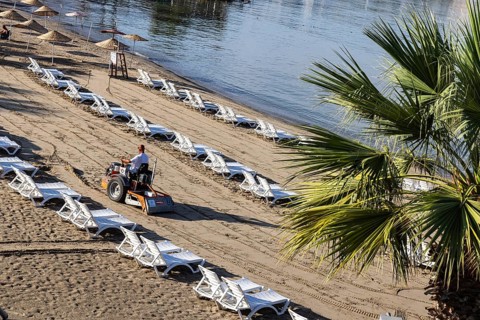 Early in the morning on the sandy beach of Kusadasi. The sunbeds are being prepared