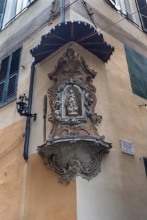 Sculpture of the Virgin Mary under a canopy on a corner house in the historic centre
