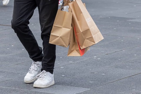 Consumer tourist lugging shopping bags