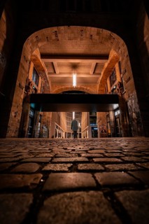 Night view of an illuminated arched brick gate