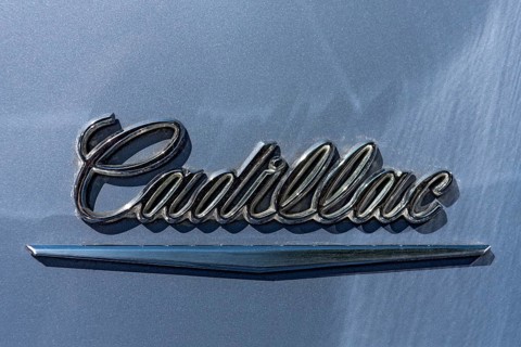 Lettering brand name Cadillac on vintage car Coupe DeVille at the rear