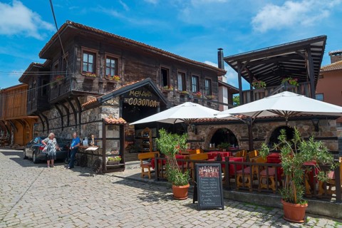 Cosy restaurant in an old town with traditional wooden architecture on a sunny day
