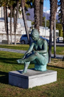 Sculpture of a seated female nude by sculptor Werner J. Mueller on the lakeside promenade of Lake Maggiore in Ascona