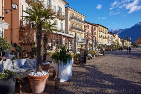 Palm trees in clay pots and outdoor catering and restaurant areas on the Piazza Giuseppe Motta promenade in Ascona
