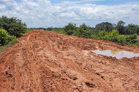 Large rain puddles in red mud of the Linden-Lethem dirt road linking Lethem and Georgetown in the rainy season