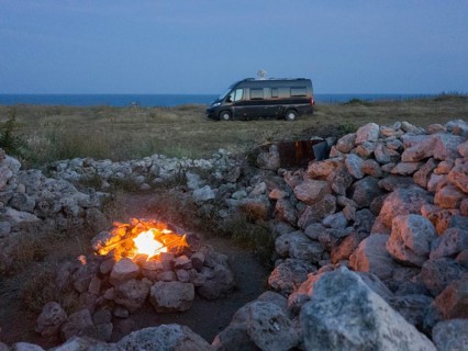 Eternal fire at night with view of motorhome